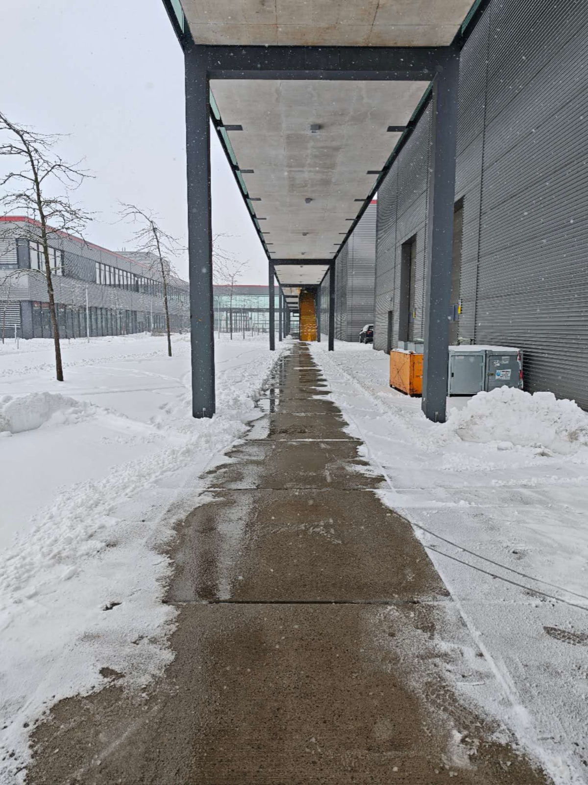 Cleared walkway along an industrial building after snowfall