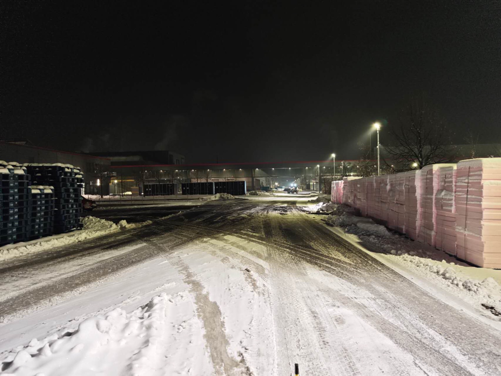 Snow-covered industrial yard with maintained traffic lanes